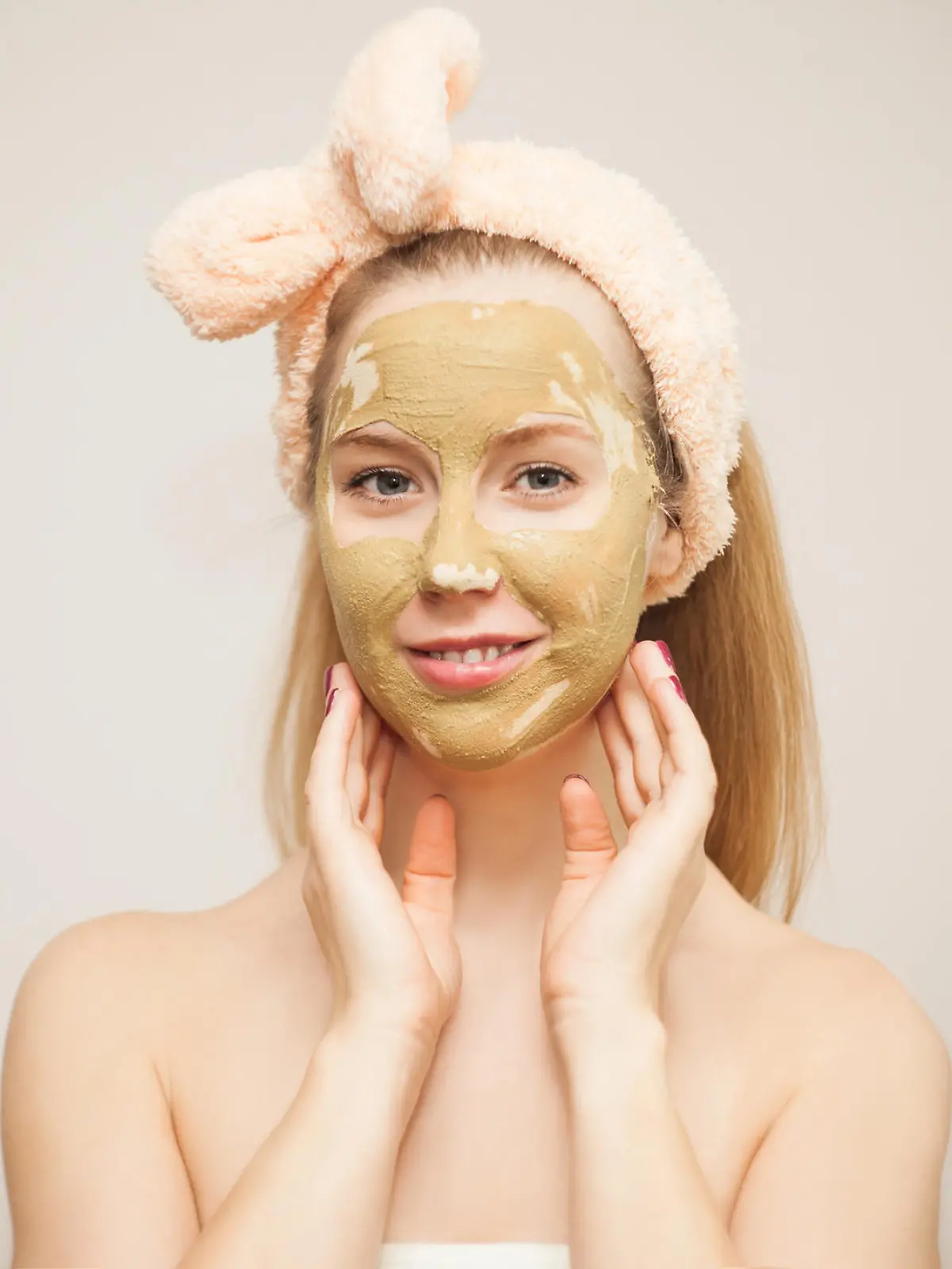 Junge Frau macht Wellness mit Schlamm-Gesichtsmaske