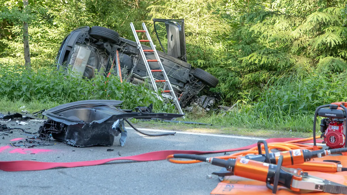 21.06.2020, Sachsen, Aue: Rettungswerkzeuge liegen neben einem Auto, das im Graben liegt. Beim Zusammenstoß von zwei Autos im Erzgebirgskreis sind am Sonntag drei Menschen gestorben. Eine Frau und zwei Kinder wurden verletzt, wie die Polizei Chemnitz mitteilte. Foto: Andre März/dpa-Zentralbild/dpa +++ dpa-Bildfunk +++