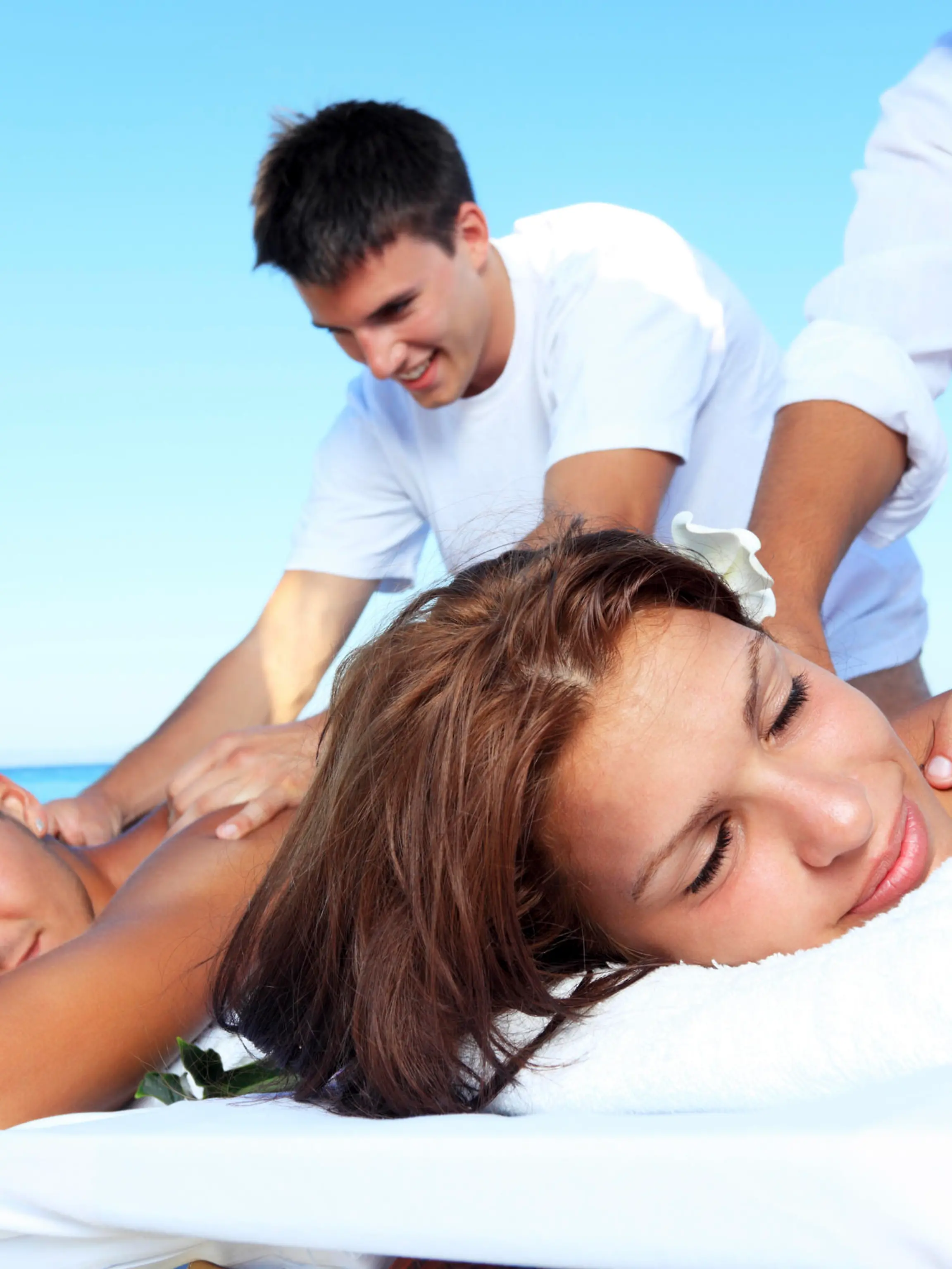 Massage shoulders happy couple on the beach.