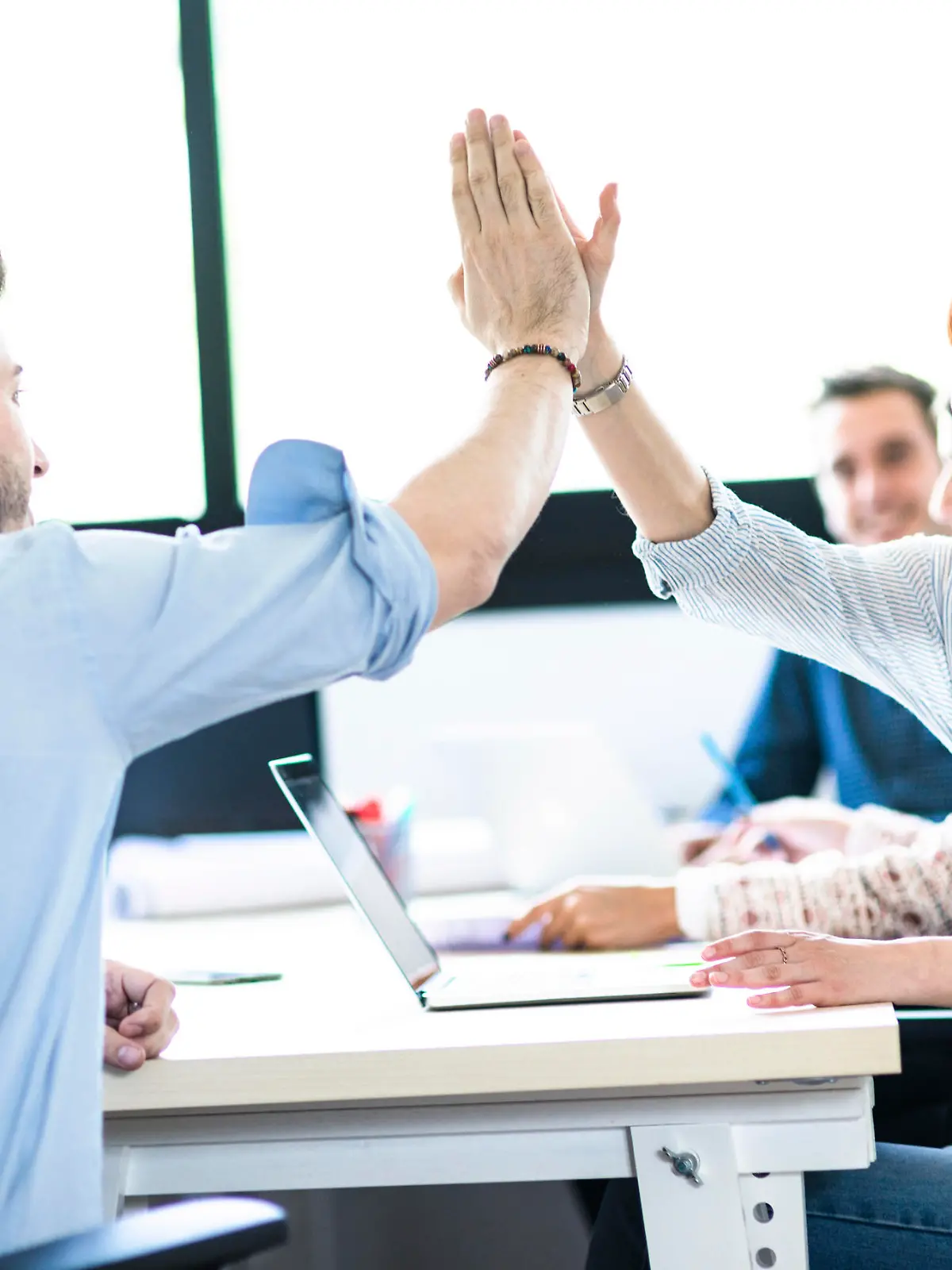 friends exchanging the highfive in the office