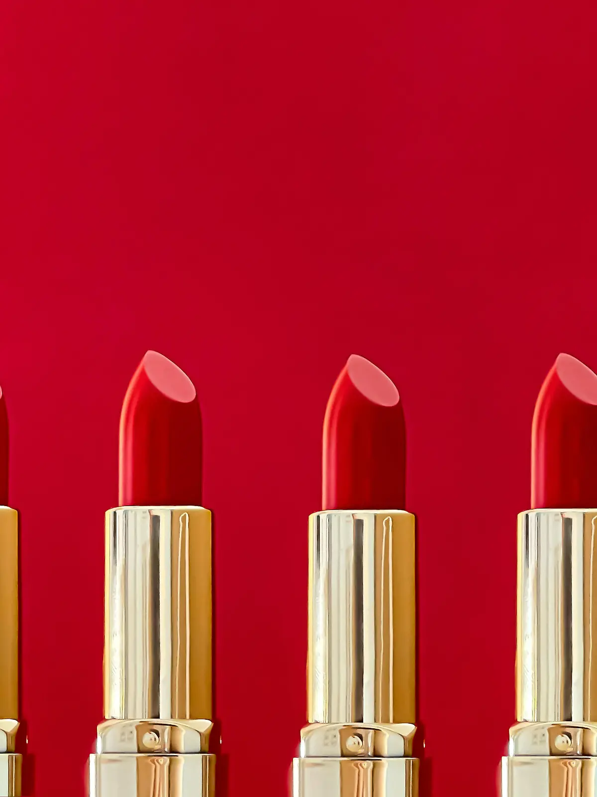 Red lipstick in golden tubes on colour background, luxury make-up and cosmetics for beauty brand product design concept