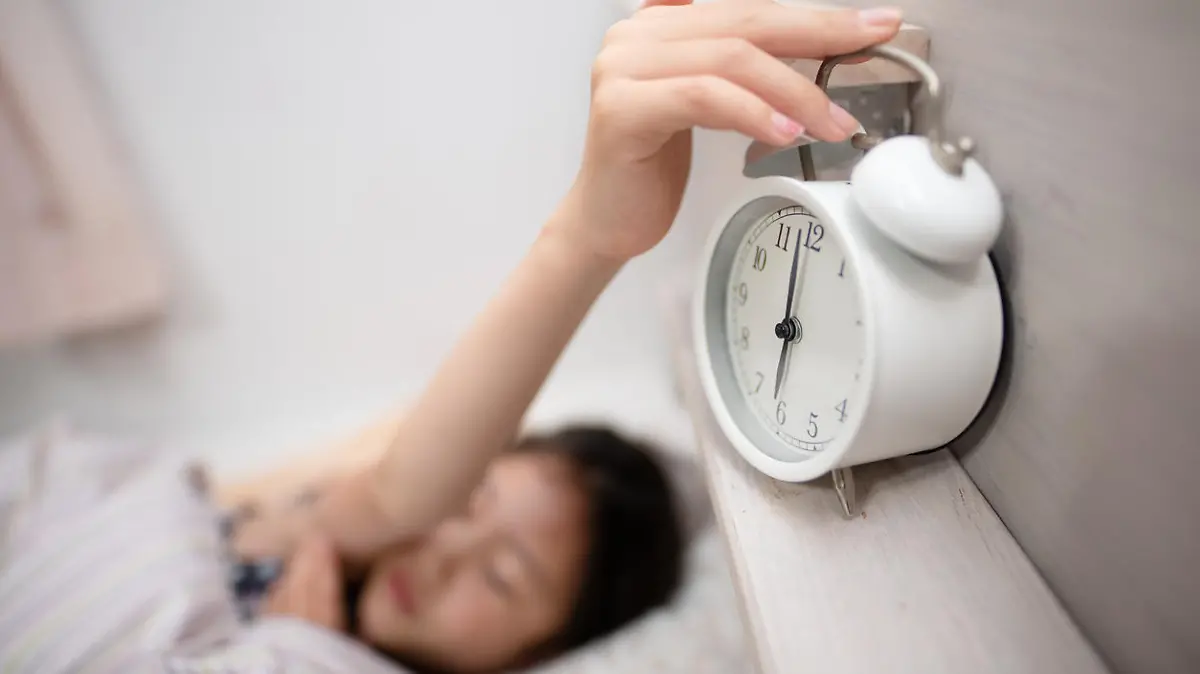 Child stopping alarm clock bell