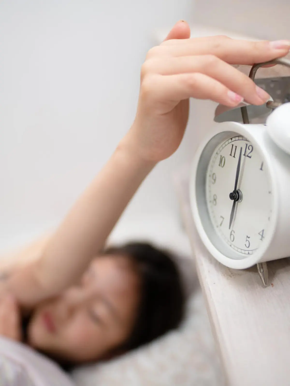 Child stopping alarm clock bell