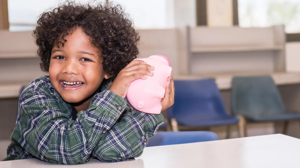 Little boys putting money into piggy bank for future savings