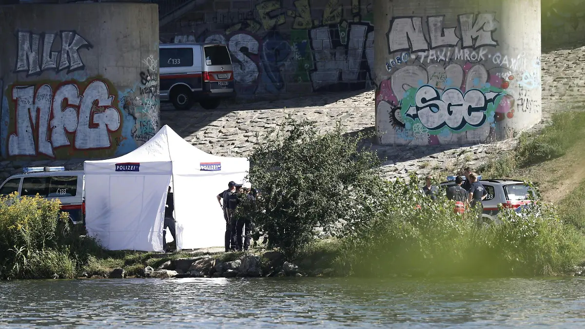 14.08.2023, Österreich, Wien: Einsatzkräfte ermitteln am Flussufer der Neuen Donau. Bei einer Hammerattacke wurde eine Frau verletzt - ihr vermisster fünfjähriger Sohn später tot in einem Seitenarm der Donau gefunden. Am Montag wurde dort eine weitere Leiche entdeckt. Foto: Tobias Steinmaurer/APA/dpa +++ dpa-Bildfunk +++