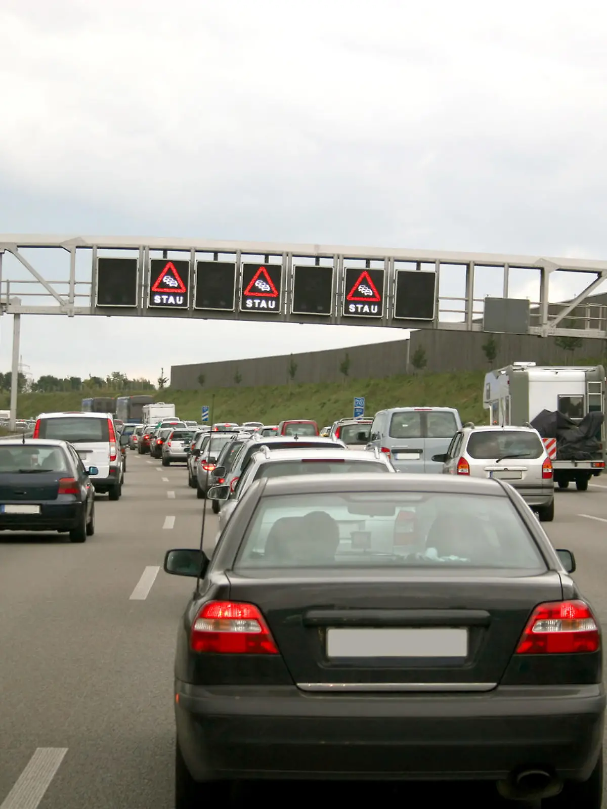 'Traffic jam on a german highway in the north of Munich - in the background digital displays with the notice ''STAU'' (traffic jam).    '