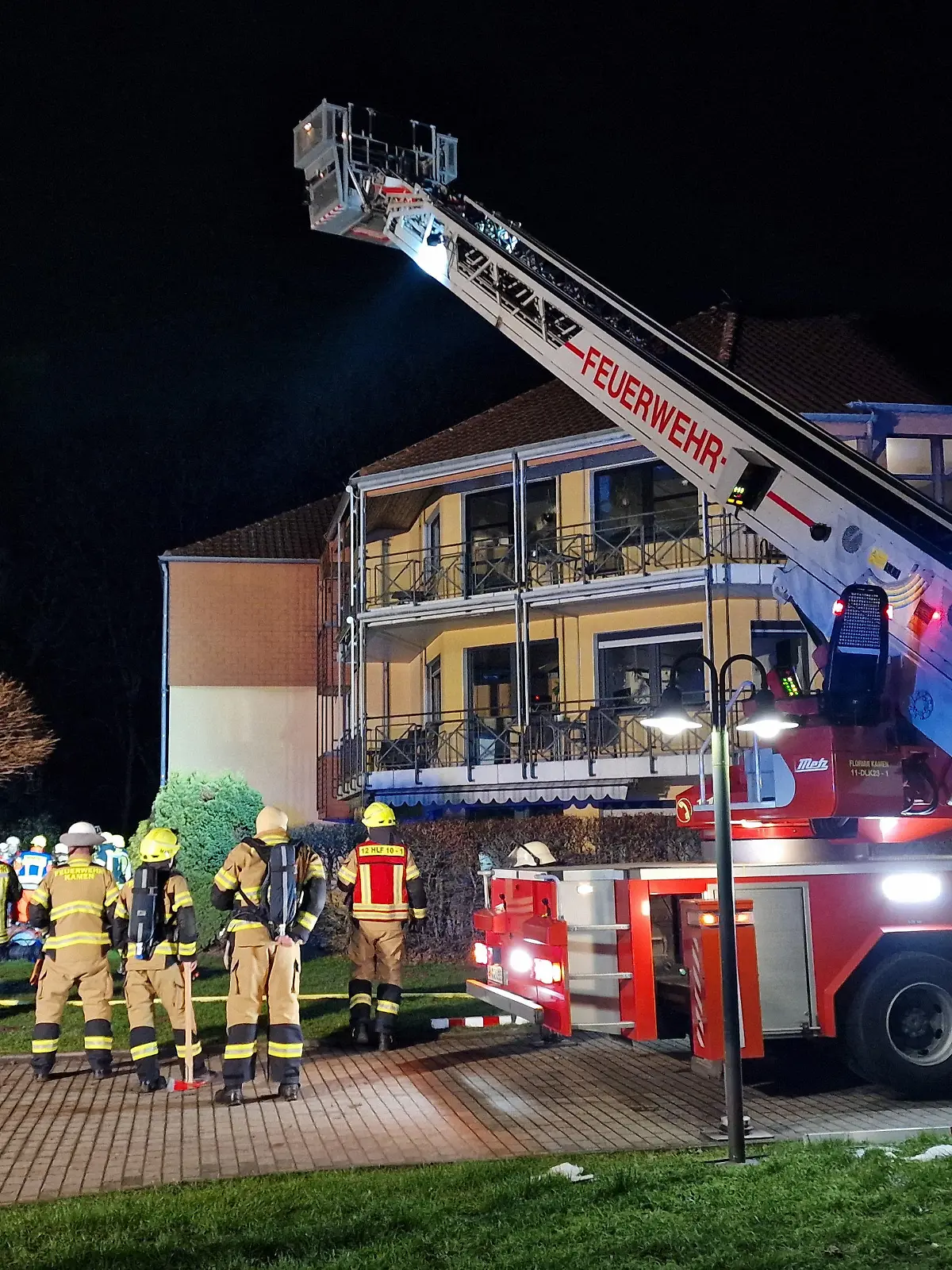 23.01.2023, Nordrhein-Westfalen, Kamen: Feuerwehrleute arbeiten vor einem Altenheim. Dort war am Montagabend ein Brand ausgebrochen. Wie viele Menschen durch den Brand im Keller des Heims im Stadtteil Heeren verletzt wurden, war zuerst unklar. Das Heim wurde evakuiert, hieß es von der Leitstelle. Foto: M. Neumann/Blaulicht Unna/dpa +++ dpa-Bildfunk +++
