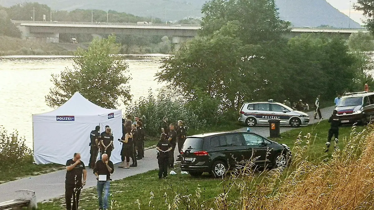 12.08.2023, Österreich, Wien: Polizisten ermitteln in am Flussufer. Ein vermisster fünfjähriger Junge ist nach einer Hammerattacke auf seine Mutter tot in einem Seitenarm der Donau gefunden worden. Wie die Polizei am 13.08.2023 mitteilte, gilt der Vater des Kindes als Verdächtiger. Foto: Tobias Steinmaurer/APA/dpa +++ dpa-Bildfunk +++
