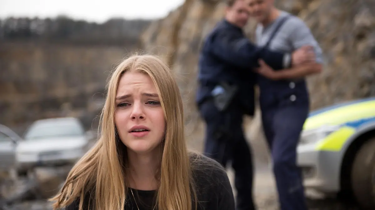 Als Fiona (Olivia Burkhart) mit Bambi (Benjamin Heinrich, r.) am Unfallort eintrifft, realisiert sie, dass Rolf tot ist und bricht zusammen...