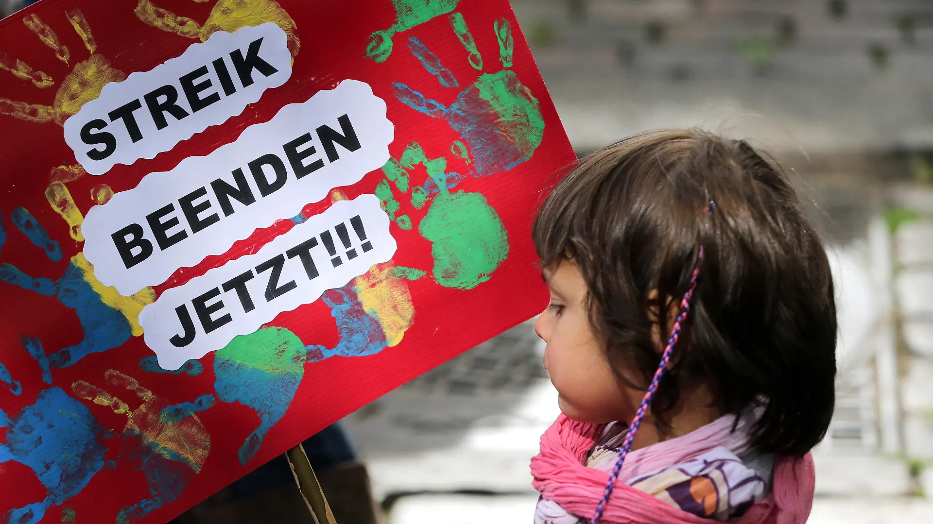 ARCHIV - Ein kleines Mädchen hält am 26.05.2015 in Hamburg bei der Kundgebung des Landeselternausschuss (LEA) Hamburg ein Plakat mit der Aufschrift «Streik Beenden Jetzt» in den Händen. Foto: Axel Heimken/dpa (zu dpa "Schlichtung im Kita-Tarifkonflikt - Streik endet" vom 04.06.2015) +++(c) dpa - Bildfunk+++