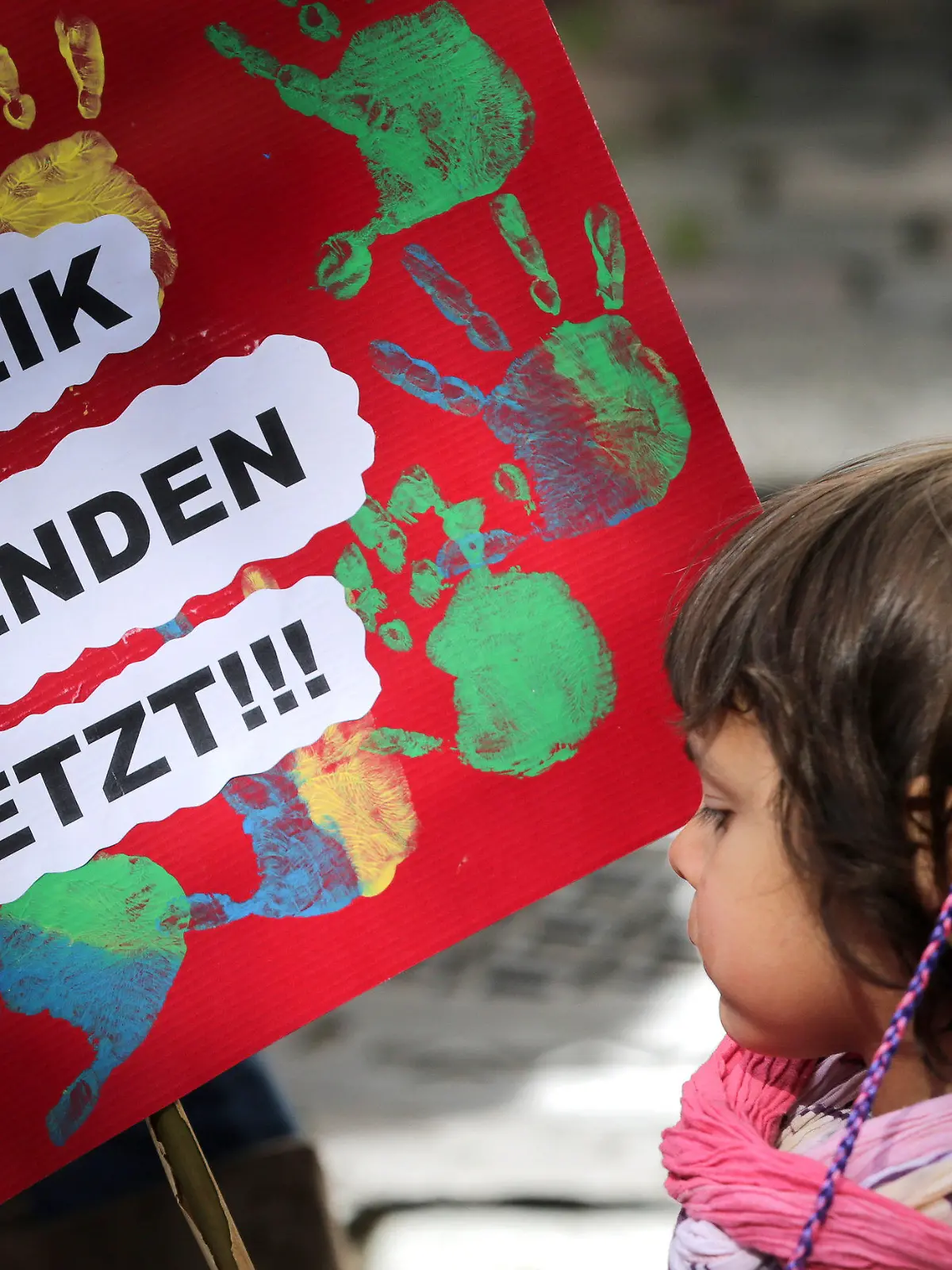 ARCHIV - Ein kleines Mädchen hält am 26.05.2015 in Hamburg bei der Kundgebung des Landeselternausschuss (LEA) Hamburg ein Plakat mit der Aufschrift «Streik Beenden Jetzt» in den Händen.  Foto: Axel Heimken/dpa (zu dpa "Schlichtung im Kita-Tarifkonflikt - Streik endet" vom 04.06.2015) +++(c) dpa - Bildfunk+++