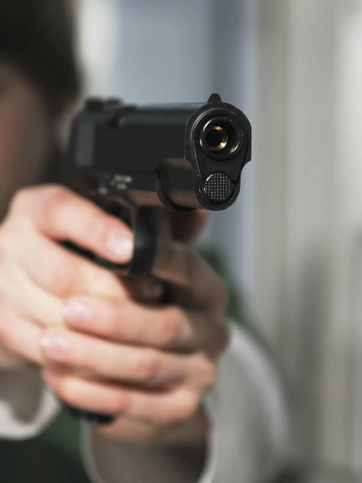 Boy aims Colt 1911 pistol |