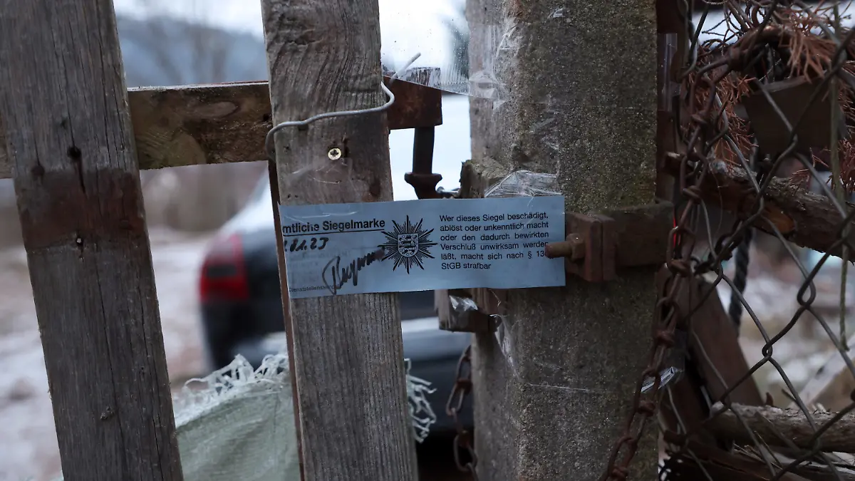 20.01.2023, Thüringen, Bad Blankenburg: Eine polizeiliche Siegelmarke befindet sich am Eingangstor zu einem Gartengrundstück am Ortsrand der Stadt. Hier wurde die Leiche eines Kindes gefunden. Die Mordkommission des Thüringer Landeskriminalamtes (LKA) ermittelt wegen des Verdachts der Tötung eines Kindes. Foto: Bodo Schackow/dpa +++ dpa-Bildfunk +++