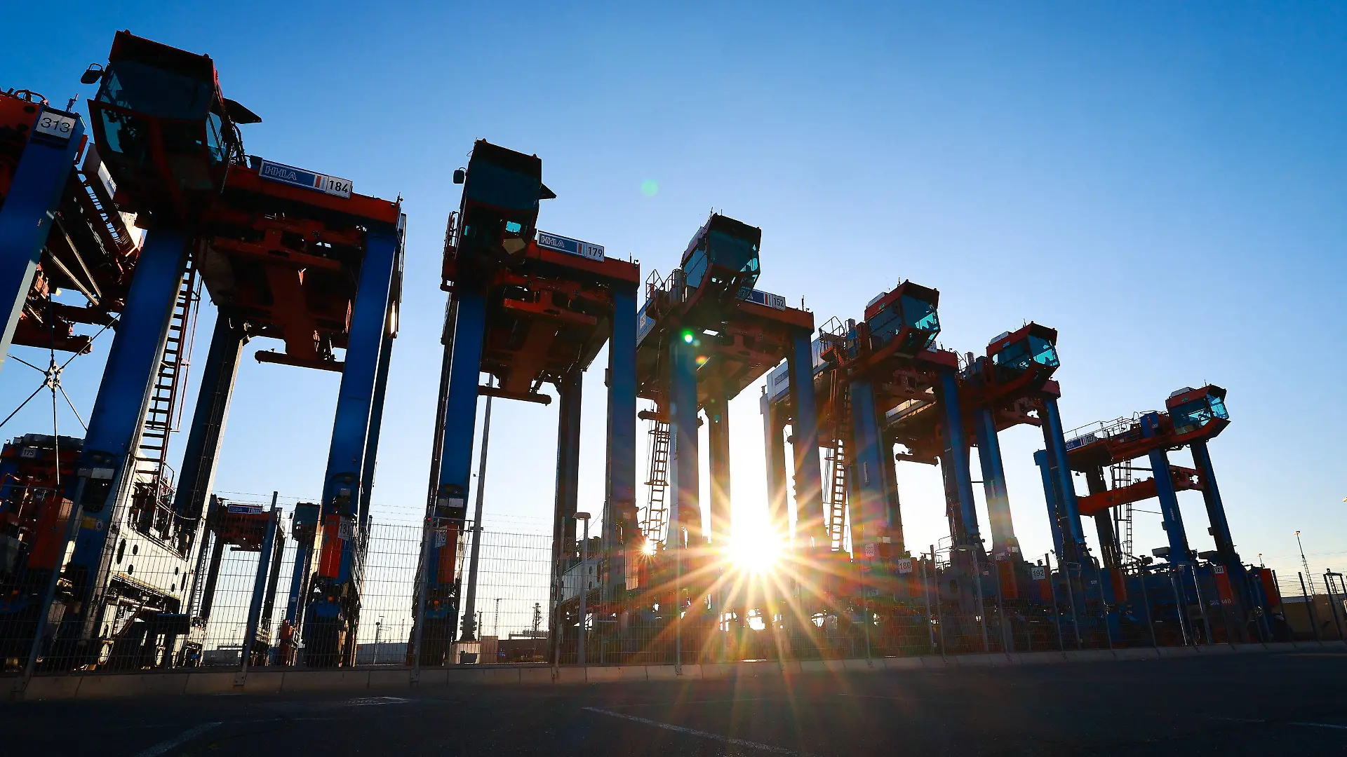 ARCHIV - 14.07.2022, Hamburg: Van Carrier (VC), Spezialfahrzeuge für den Containerumschlag, stehen auf dem Gelände des Container Terminal Burchardkai (CTA) der HHLA (Hamburger Hafen und Logistik AG). Die deutsche Wirtschaft wird nach Einschätzung vieler Ökonomen 2023 schrumpfen, die Teuerung dürfte zunächst hoch bleiben. Dennoch ist das Bild längst nicht mehr so düster wie vor Monaten - auch weil der Staat mit Preisbremsen und milliardenschweren Entlastungspakten gegensteuert. (zu dpa «Fällt die Rezession aus? Konjunkturaussichten nicht mehr ganz so trüb») Foto: Christian Charisius/dpa +++ dpa-Bildfunk +++