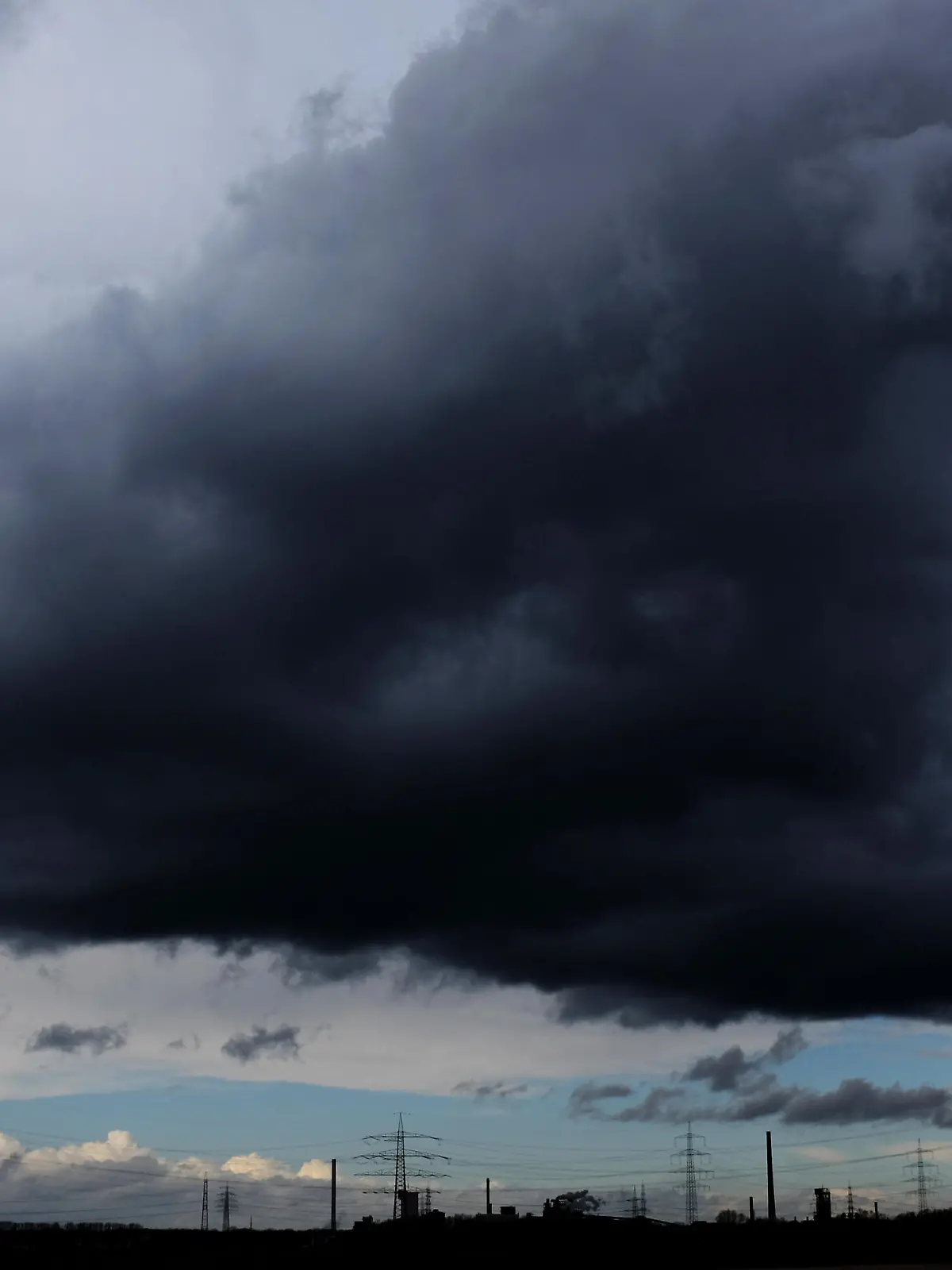 dpatopbilder Bei starkem Wind ziehen am 28.03.2016 dunkle Regenwolken über Duisburg (Nordrhein-Westfalen). Am Ostermontag gibt es teilweise schwere Sturmböen, Regenschauer und vereinzelte Gewitter in Nordrhein-Westfalen. Foto: Martin Gerten/dpa