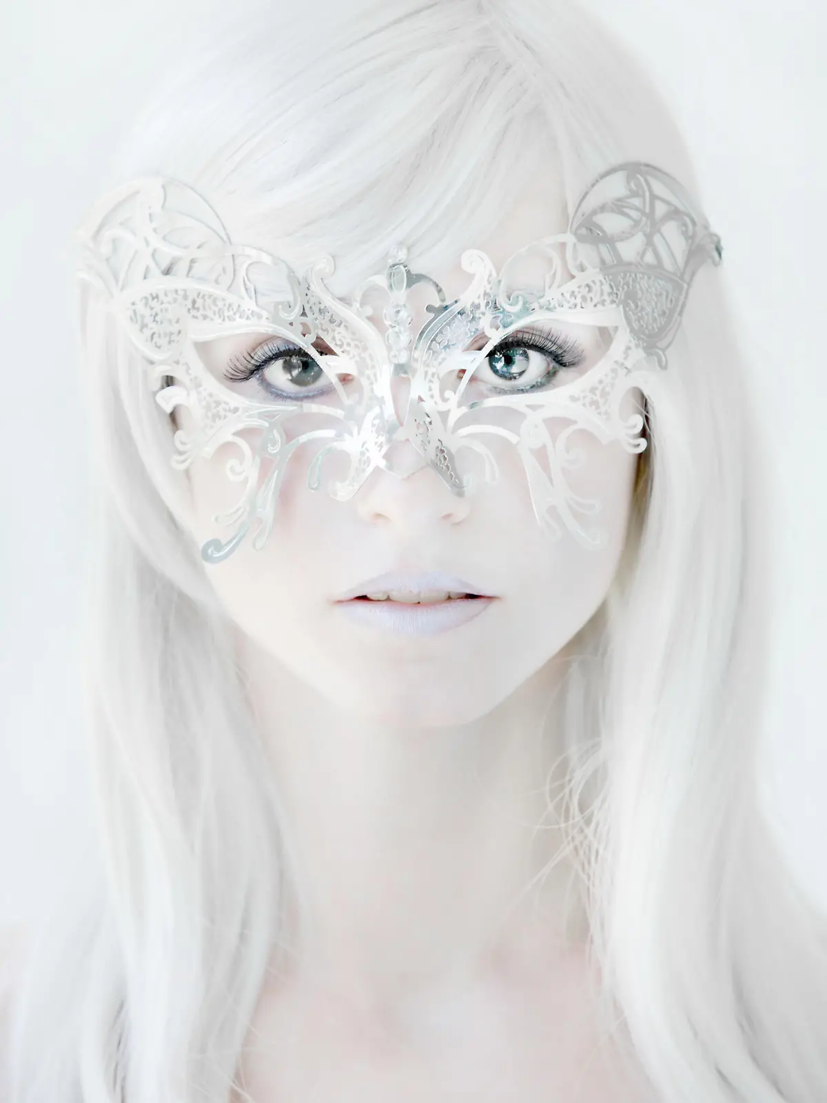 A beautiful young woman in a silver butterfly mask.