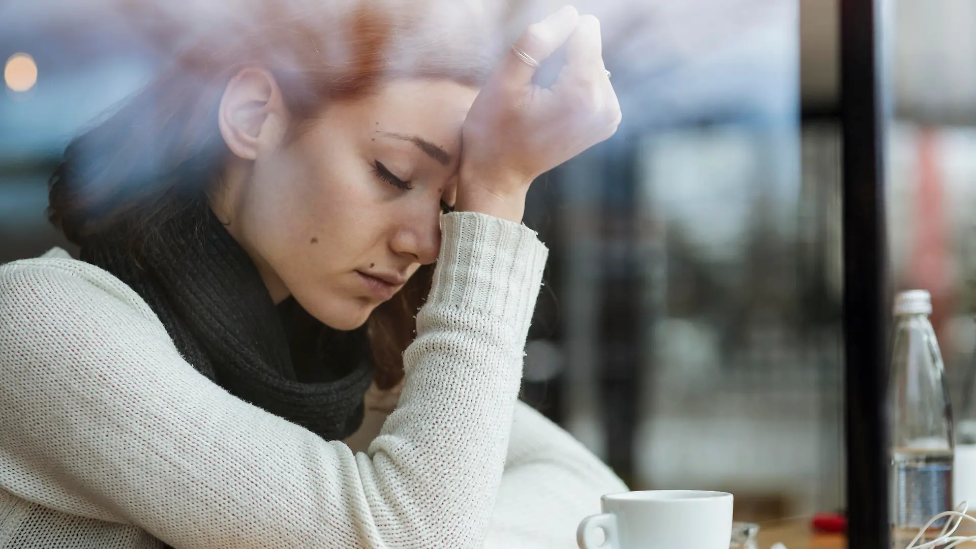 Young girl smoking and feeling depressed in a bar