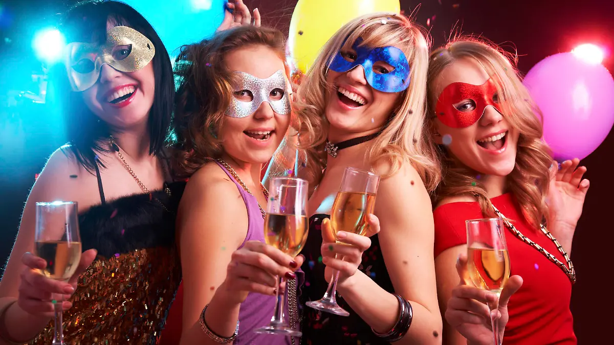 Portrait of happy young girls under masks on the party
