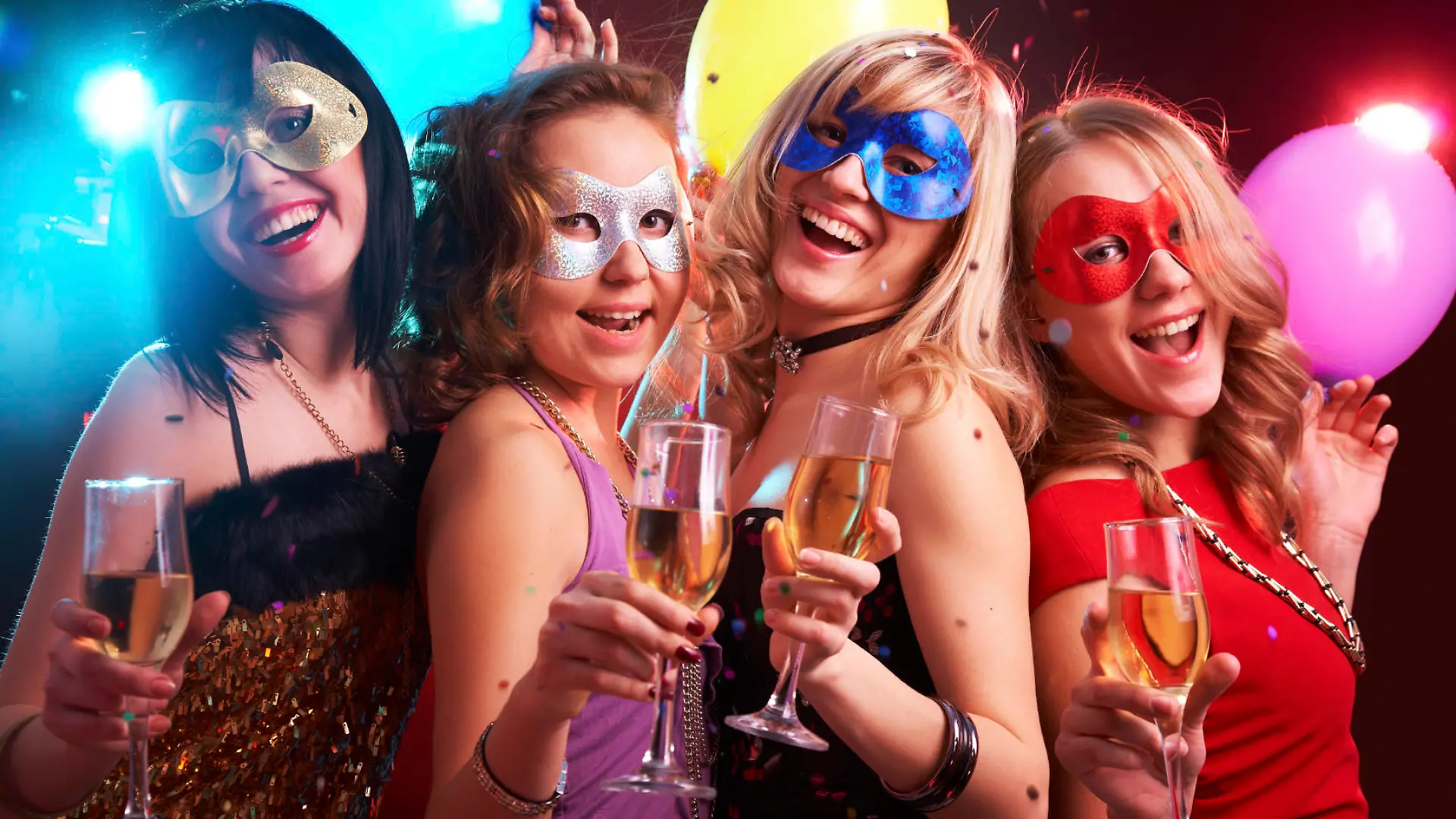 Portrait of happy young girls under masks on the party