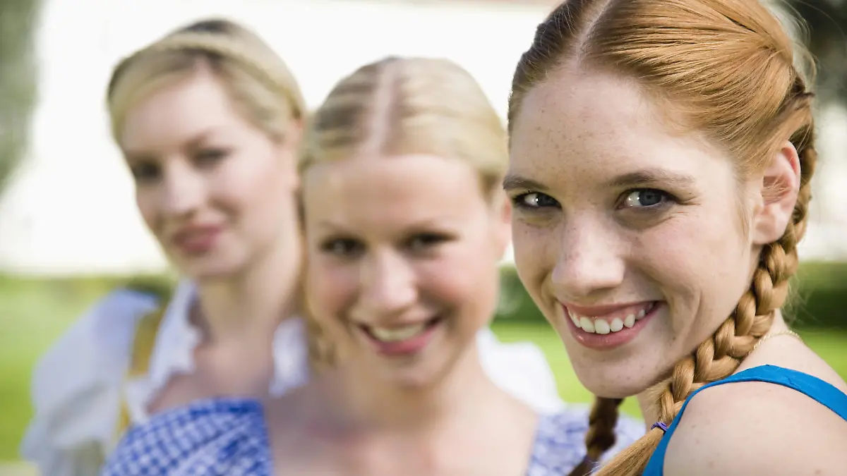 Germany, Bavaria, Upper Bavaria, Three women in traditional costumes, smiling, portrait