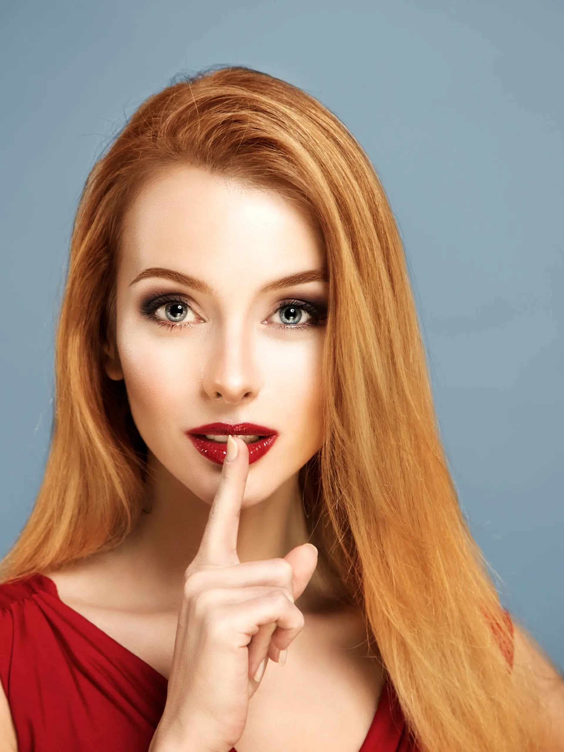 Beauty Portrait of Sexy Woman with Finger on her Red Lips Showing Hush. Long Hair. Holiday Makeup. Smoky Eyes and Red Lipstick. Glamour Woman.