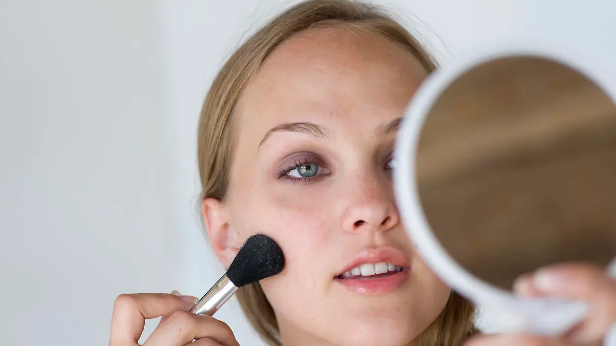 portrait of woman applying make up with brush                                                                                                                                                            Keine Weitergabe an Drittverwerter.