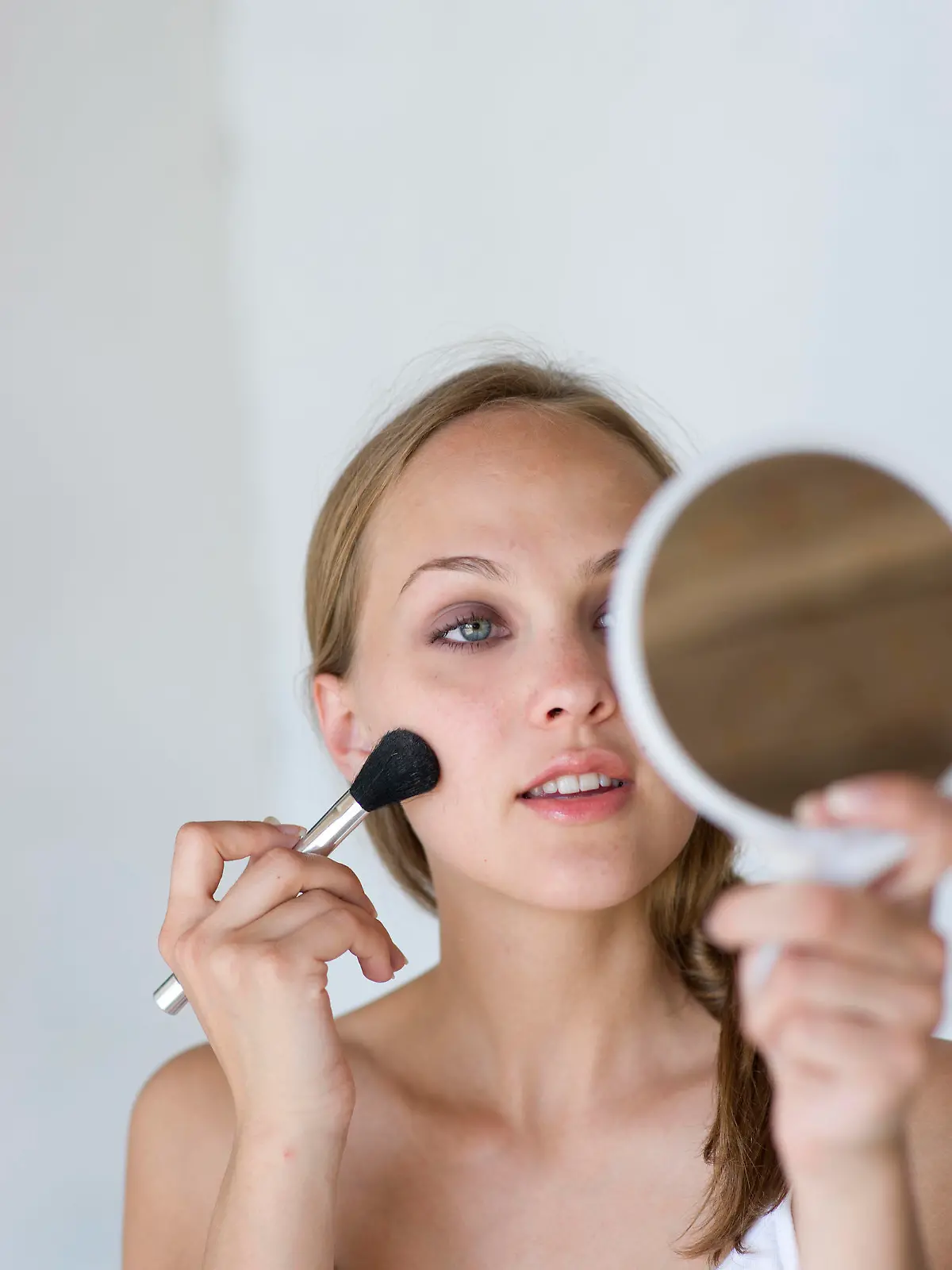 portrait of woman applying make up with brush                                                                                                                                                            Keine Weitergabe an Drittverwerter.