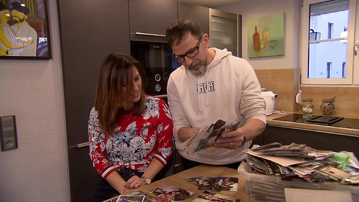 Gigis Eltern, Cinzia und Marcello, schauen sich alte Kinderfotos an