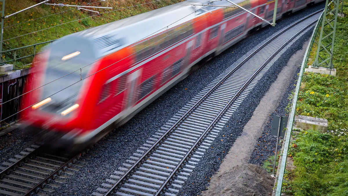 ARCHIV - 28.10.2022, Mecklenburg-Vorpommern, Schwerin: Ein Nahverkehrszug fährt über die neu gebaute Bahnstrecke zum Schweriner Hauptbahnhof (Aufnahme mit langer Belichtungszeit)(zu dpa: "Starttermin für 49-Euro-Ticket weiter offen - EVG rechnet mit April"). Foto: Jens Büttner/dpa +++ dpa-Bildfunk +++