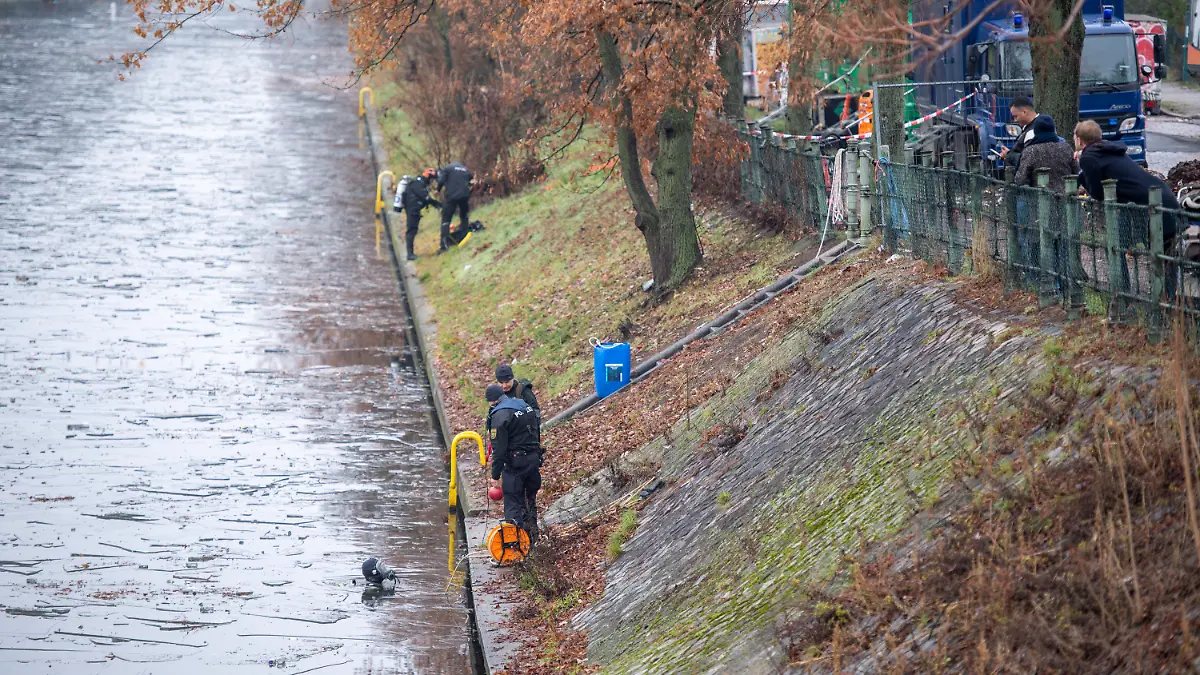 25.12.2022, Berlin: Polizeitaucher steigen für die Suche in den Landwehrkanal. Die Suche nach Beweisstücken im Fall des spektakulären Juwelendiebstahls aus dem Grünen Gewölbe in Dresden geht auch zu Weihnachten weiter. Nach Angaben der Polizeidirektion Dresden vom Sonntag suchen seit den Morgenstunden etwa 20 Polizeitaucher aus verschiedenen Bundesländern im Landwehrkanal am Kiehlufer im Bezirk Neukölln nach Beweisstücken. Foto: Christophe Gateau/dpa +++ dpa-Bildfunk +++