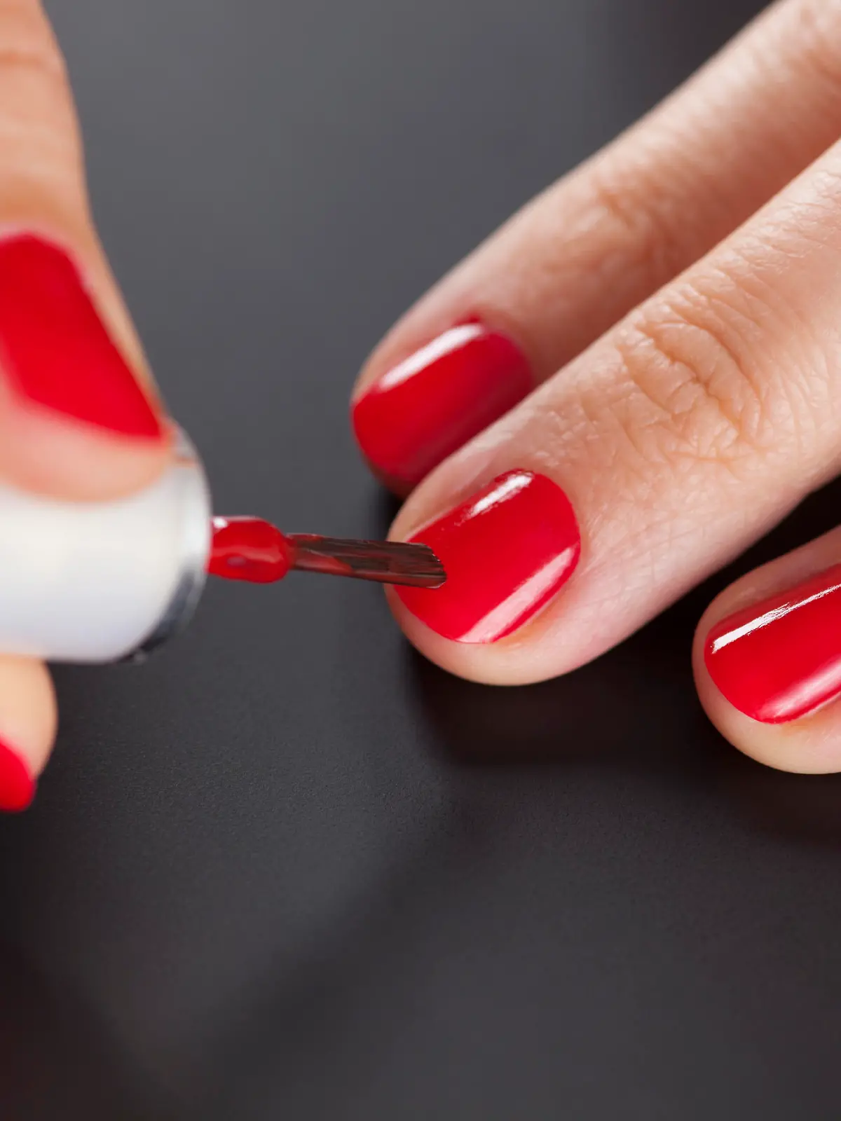 Painting nails. Black background.
