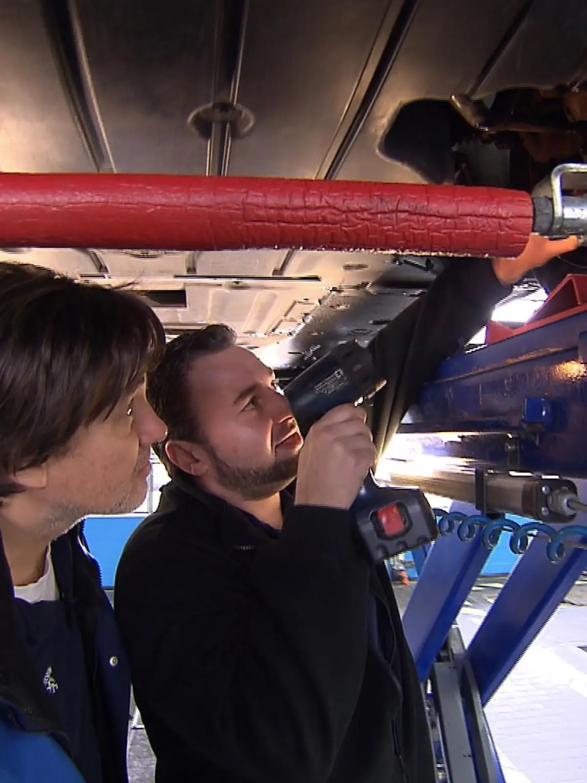 In der Rolle des Arbeitslosen Rolf Diehl arbeitet TÜV Hessen-Chef Reiner Block (l.) unerkannt im eigenen Unternehmen und lässt sich von TÜV-Mitarbeiter Martin Klingebiel das Vorgehen bei der Hauptuntersuchung von Autos erklären.