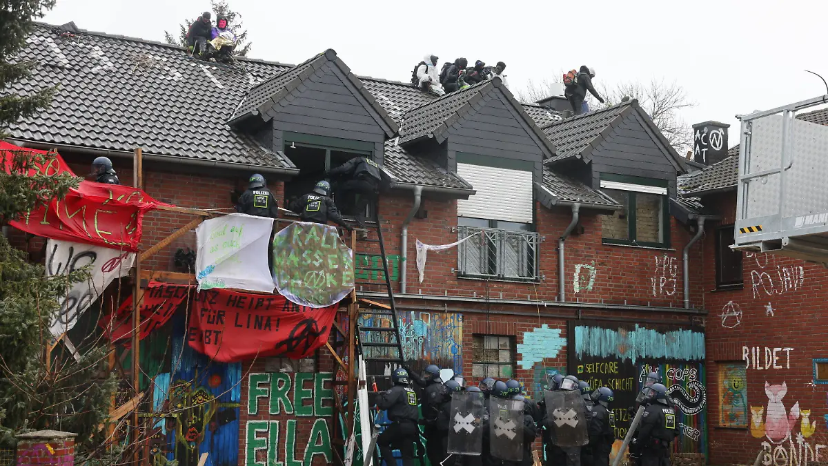 12.01.2023, Nordrhein-Westfalen, Erkelenz: Polizisten verschaffen sich am zweiten Tag der Räumung im von Klimaaktivisten besetzten Braunkohleort Lützerath Zutritt zu einem Gebäude. Der Energiekonzern RWE will die unter Lützerath liegende Kohle abbaggern - dafür soll der Weiler auf dem Gebiet der Stadt Erkelenz am Braunkohletagebau Garzweiler II abgerissen werden. Foto: Oliver Berg/dpa +++ dpa-Bildfunk +++