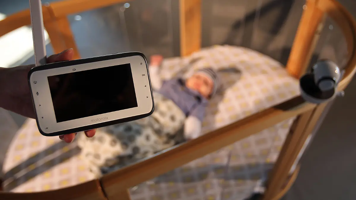 Eine Frau hält am 04.09.2014 in Köln (Nordrhein-Westfalen) das Video-Babyfone MBP854 HD-Connect über ein Kinderbett. Die weltgrößte Messe für Kinderausstattung «Kind+Jugend» ist vom 11.-14.9.2014 in Köln zu sehen. Foto: Oliver Berg/dpa