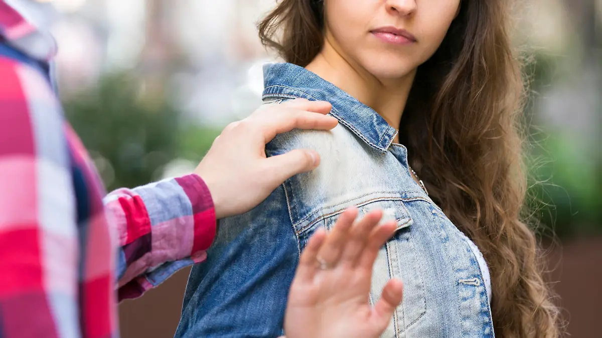 Man is trying to pick up girl on city street outdoors. She is irritated by him and refuses to talk