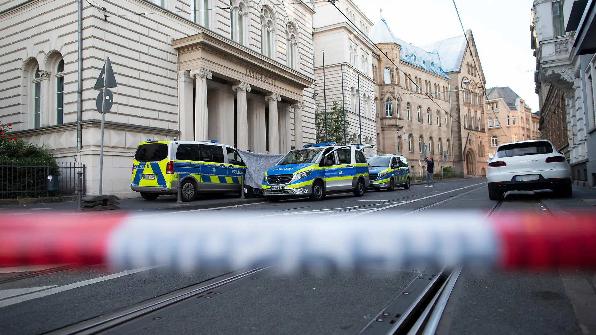 28.06.2022, Nordrhein-Westfalen, Bonn: Die Polizei hat den Bereich vor dem Bonner Landgericht abgesperrt. Vor dem Bonner Landgericht ist ein abgetrennter menschlicher Kopf abgelegt worden. Passanten hätten die Polizei am frühen Dienstagabend alarmiert, dass im Eingangsbereich des Gerichts ein Körperteil sei, sagte ein Polizei-Sprecher am Abend in Bonn. Foto: Thomas Banneyer/dpa - ACHTUNG: Kennzeich(en) wurde(n) aus rechtlichen Gründen gepixelt +++ dpa-Bildfunk +++