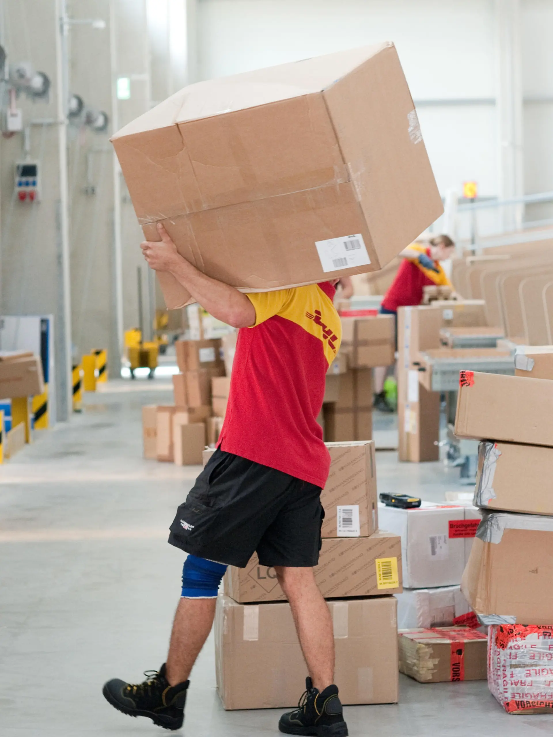 Ein Mitarbeiter der Deutschen Post DHL arbeitet am 03.07.2013 in Berlin in der mechanisierten Zustellbasis (MechZB). Die dort eingebaute Verteilanlage kann automatisch die Sendungen dem entsprechenden Zusteller und den Zustellbezirken zuordnen.  Bis Ende 2013 soll es bundesweit insgesamt 25 Standorte mit der mechanisierten Verteiltechnik geben. Foto: Klaus-Dietmar Gabbert