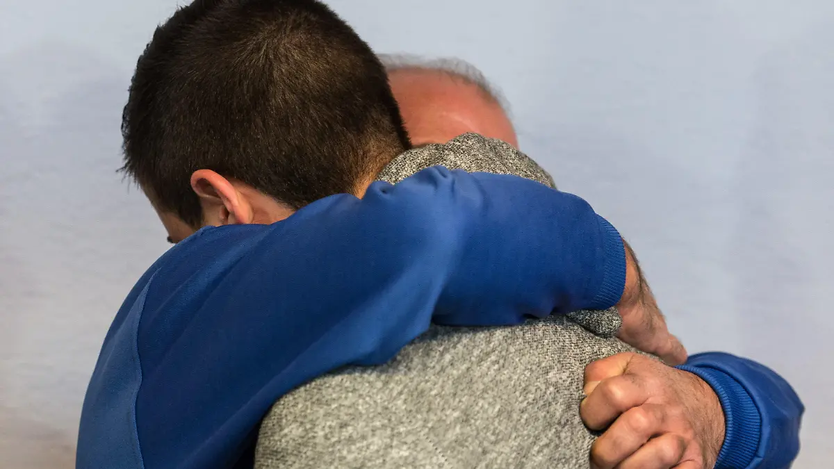 Der Angeklagte Vater Moustapha Y. (l, blauer Pullover) umarmt am 08.04.2015 im Landgericht in Freiburg (Baden-Württemberg) vor dem Prozessbeginn seinen Sohn Akram. Im sogenannten "Lynchmord"-Prozess soll ein damals 17-Jähriger gemeinsam mit seinem Vater und zwei Freunden den mutmaßlichen Vergewaltiger seiner Schwester in einen Hinterhalt gelockt und mit 23 Messerstichen getötet haben. Foto: Patrick Seeger/dpa +++(c) dpa - Bildfunk+++