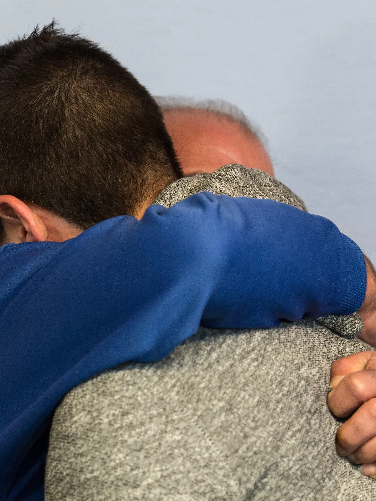 Der Angeklagte Vater Moustapha Y. (l, blauer Pullover) umarmt am 08.04.2015 im Landgericht in Freiburg (Baden-Württemberg) vor dem Prozessbeginn seinen Sohn Akram. Im sogenannten "Lynchmord"-Prozess soll ein damals 17-Jähriger gemeinsam mit seinem Vater und zwei Freunden den mutmaßlichen Vergewaltiger seiner Schwester in einen Hinterhalt gelockt und mit 23 Messerstichen getötet haben. Foto: Patrick Seeger/dpa +++(c) dpa - Bildfunk+++