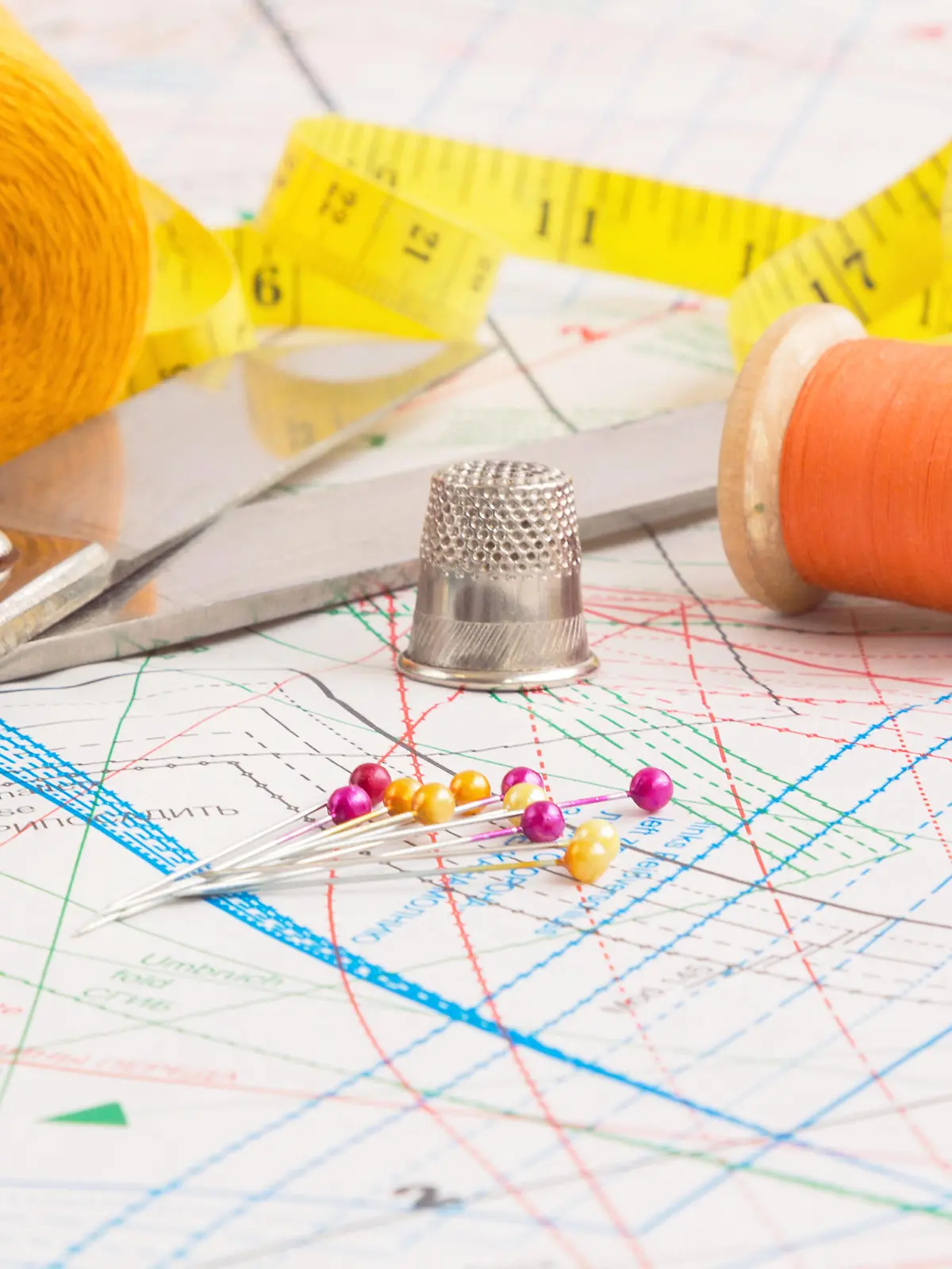 Sewing items background with old scissors, thread spools and tape measure