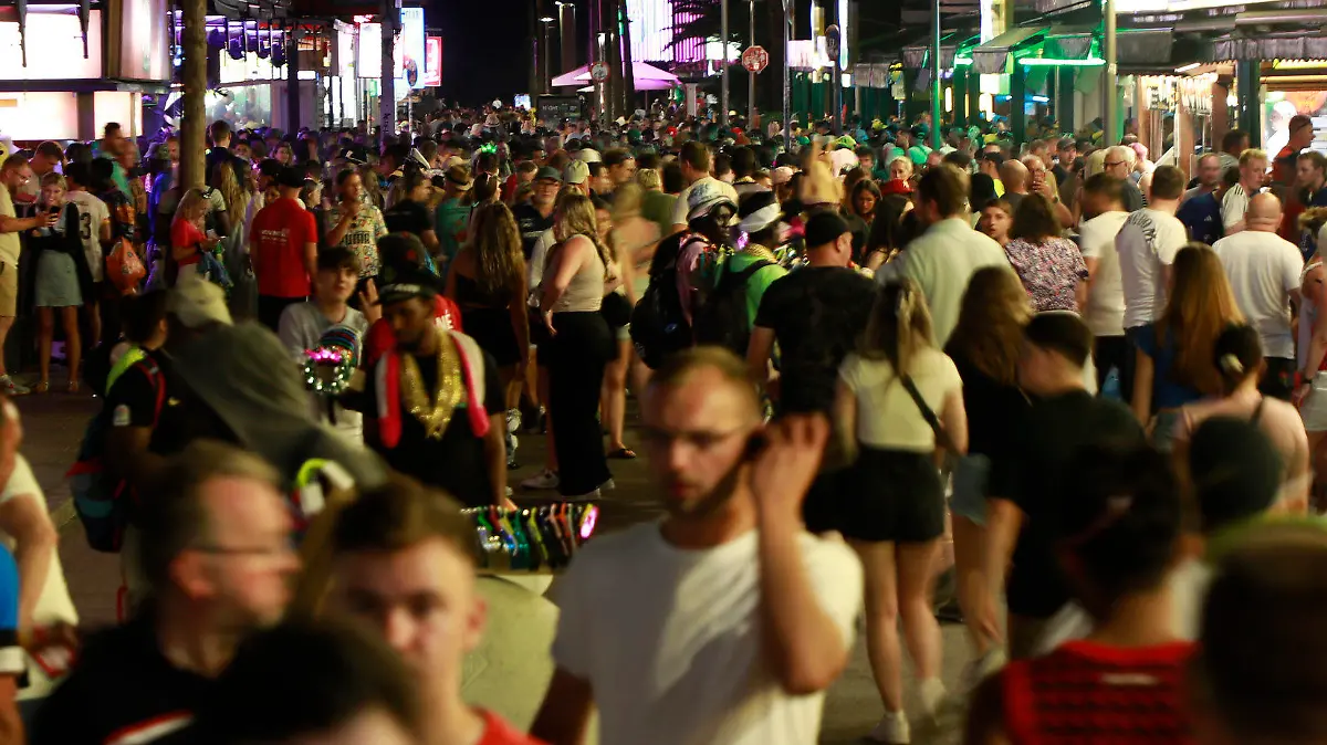 PRODUKTION - 09.06.2023, Spanien, Palma: Menschen sind auf der Schinkenstraße unweit des Ballermann unterwegs. Unternehmer schlagen Alarm, Nachbarn haben Angst. Am Ballermann sorgen die Partyurlauber dieses Jahr bereits lange vor Start der Hauptsaison für Ärger. (zu dpa "Sauftourismus nicht zu bremsen - Angst vor dem Sommer auf Mallorca") Foto: Clara Margais/dpa +++ dpa-Bildfunk +++