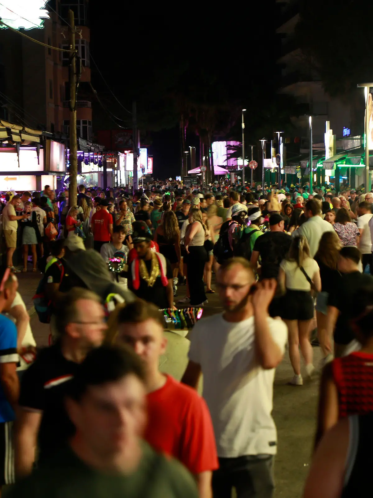PRODUKTION - 09.06.2023, Spanien, Palma: Menschen sind auf der Schinkenstraße unweit des Ballermann unterwegs. Unternehmer schlagen Alarm, Nachbarn haben Angst. Am Ballermann sorgen die Partyurlauber dieses Jahr bereits lange vor Start der Hauptsaison für Ärger. (zu dpa "Sauftourismus nicht zu bremsen - Angst vor dem Sommer auf Mallorca") Foto: Clara Margais/dpa +++ dpa-Bildfunk +++