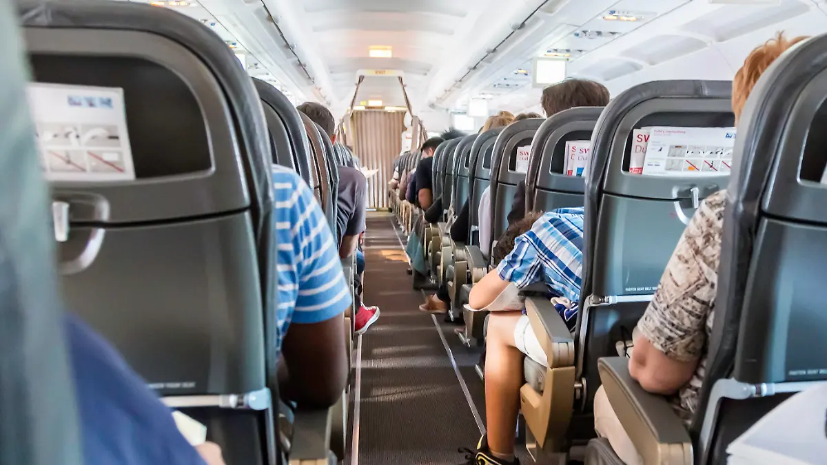 Geneve, Switzerland - August, 22nd 2014: Anxious passengers seen from behind inside a Swiss airliner taking off from Geneve airport. An Airbus 319 jet, about to embark.