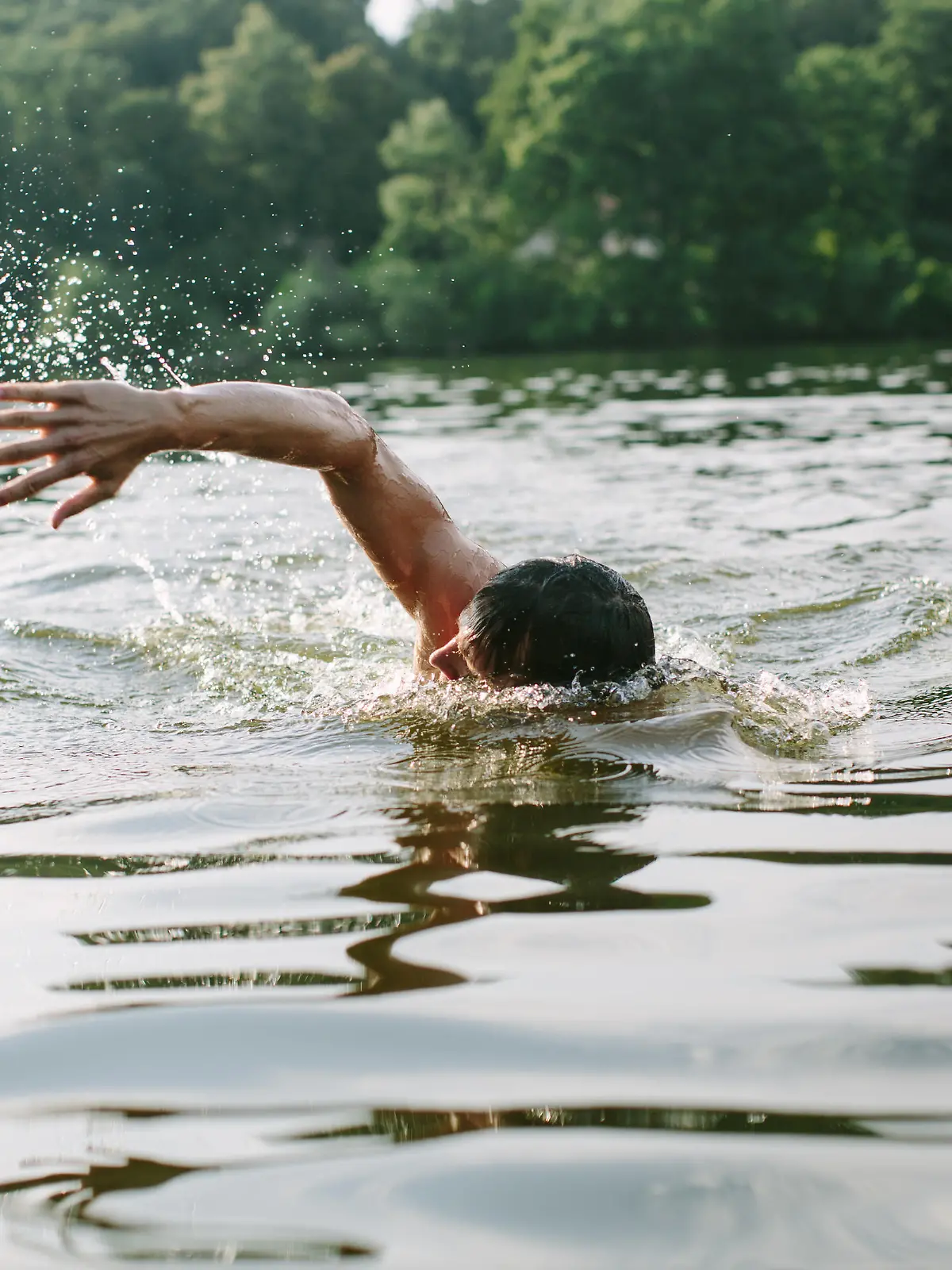 Young man swimming in a lake in Berlin's surroundings