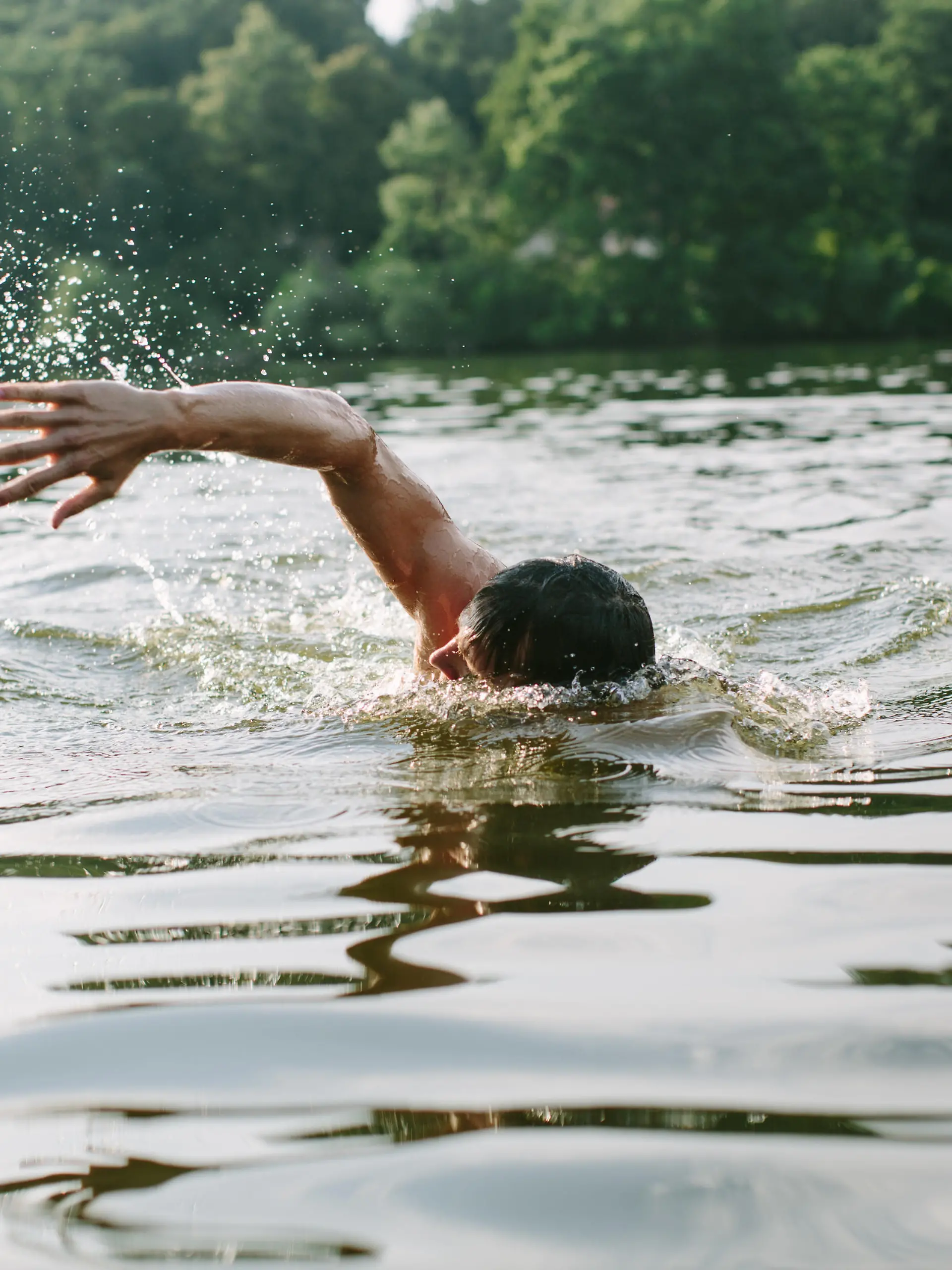 Young man swimming in a lake in Berlin's surroundings