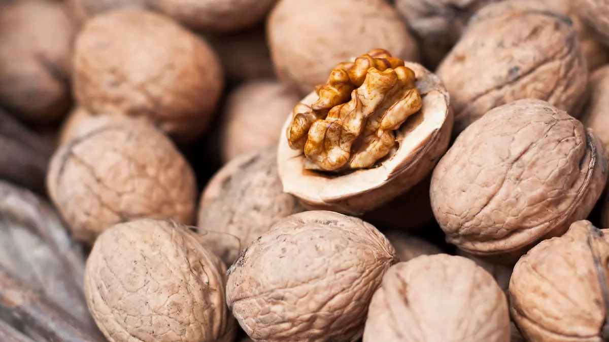 open a walnut on a background of whole nuts