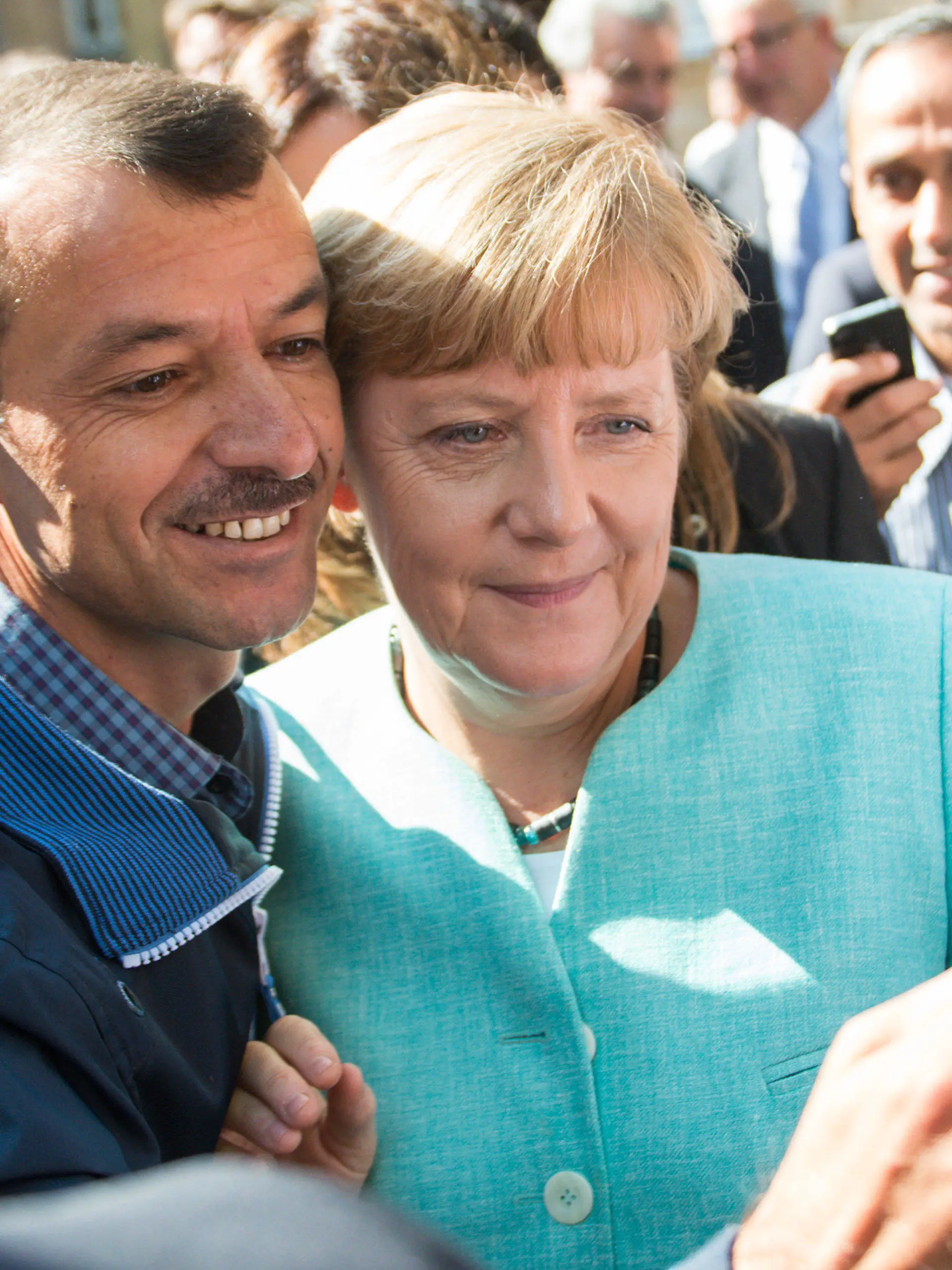 ARCHIV - Bundeskanzlerin Angela Merkel (CDU) lässt sich am 10.09.2015 nach dem Besuch einer Erstaufnahmeeinrichtung für Asylbewerber der Arbeiterwohlfahrt (AWO) und der Außenstelle des Bundesamtes für Migration und Flüchtlinge in Berlin-Spandau für ein Selfie zusammen mit einem Flüchtling fotografieren. Foto: Bernd von Jutrczenka/dpa (zu dpa «Zwischen Reem und Seehofer - Merkels Weg zur Flüchtlingskanzlerin») +++(c) dpa - Bildfunk+++