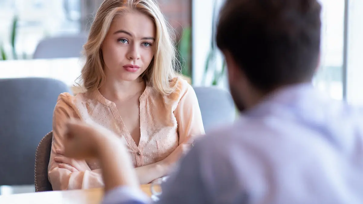 Bad date. Young woman feeling bored during dinner at cafe, unhappy with her boyfriend, disinterested in conversation. Stressed couple having difficulties in relationship, arguing in coffee shop