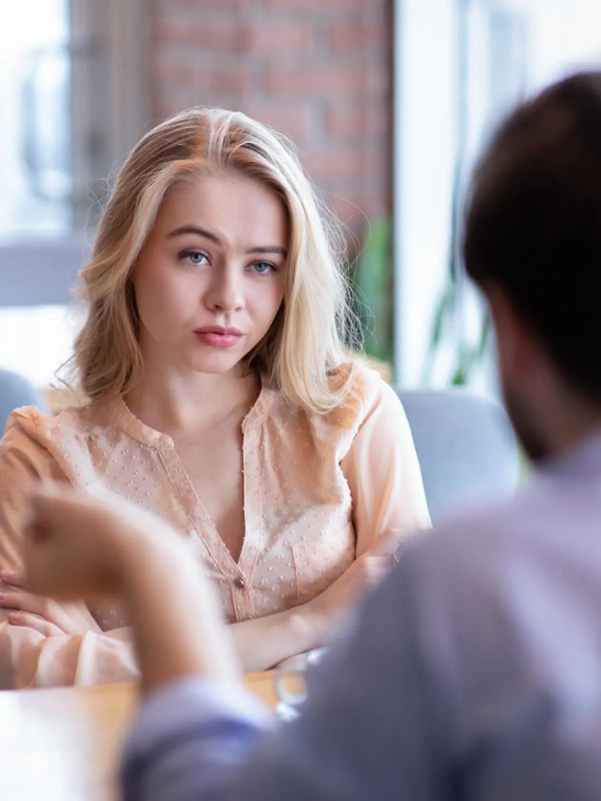 Bad date. Young woman feeling bored during dinner at cafe, unhappy with her boyfriend, disinterested in conversation. Stressed couple having difficulties in relationship, arguing in coffee shop