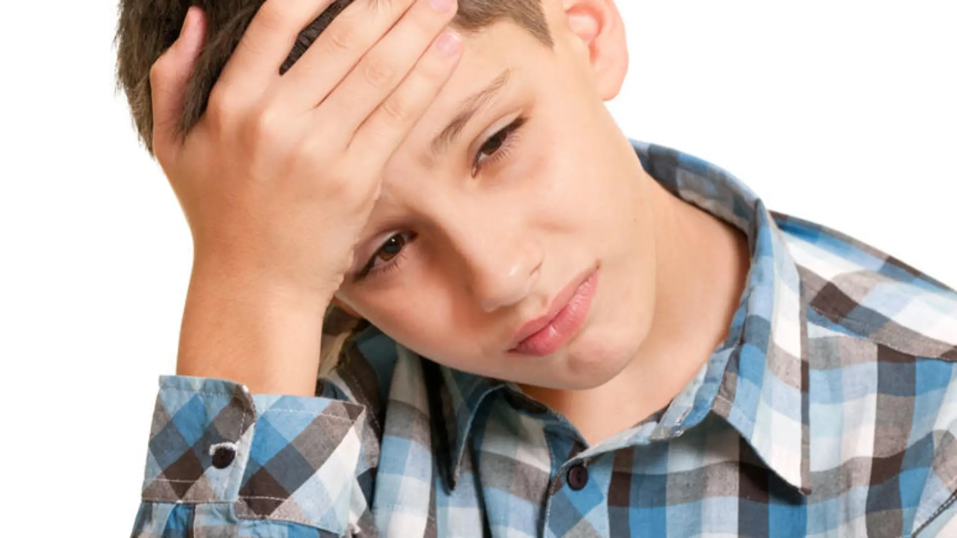 A closeup portrait of a sad boy holding his head with his hand; isolated on the white background